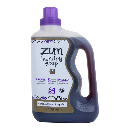 A bottle of Zum brand laundry soap in a purple liquid soap container, with a label indicating Frankincense & Myrrh scent and 64 oz volume.